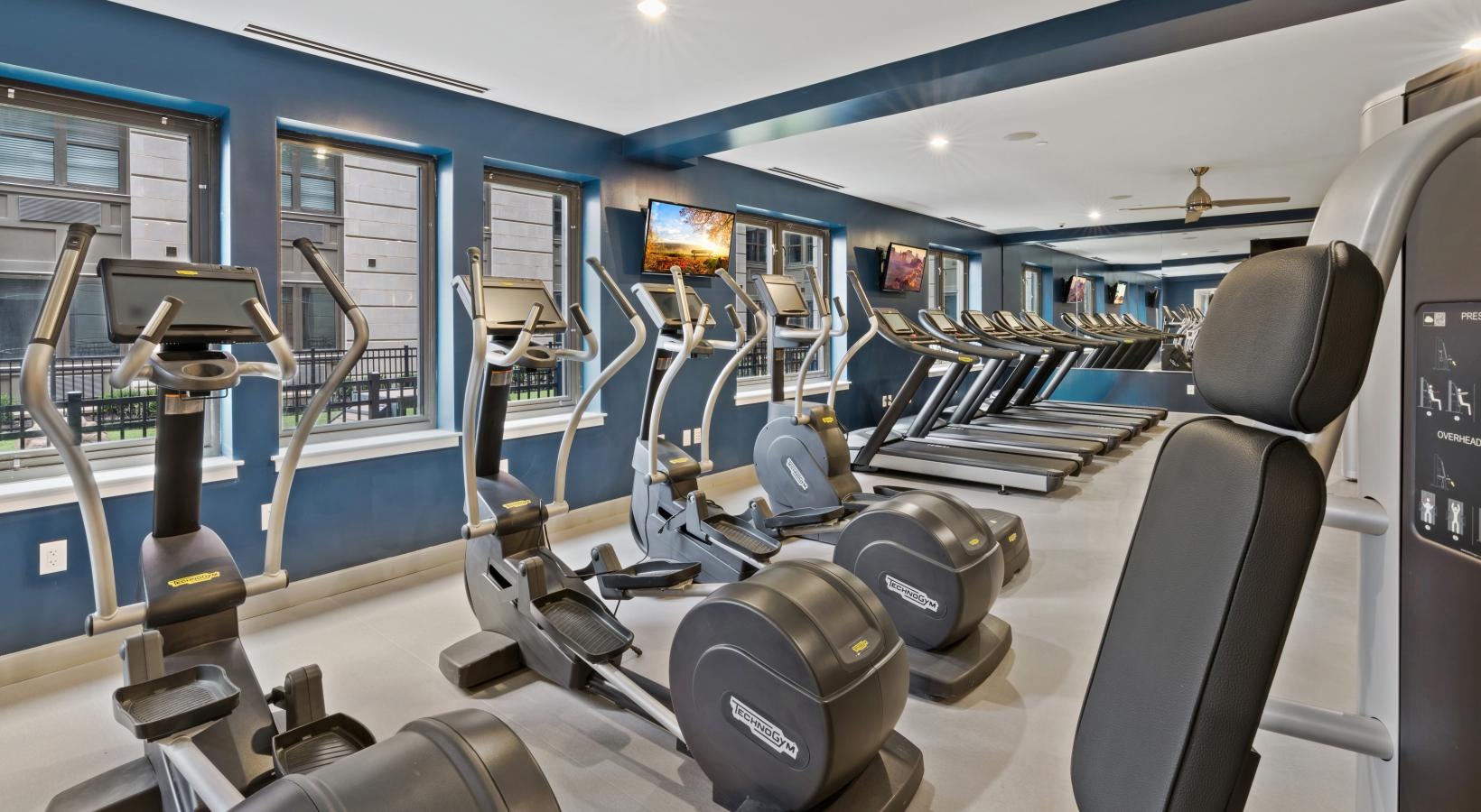 Get your workout on exercise equipment inside of a gym with windows
