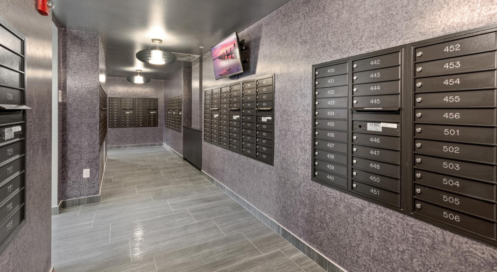 Find your perfect fit at The Quincy a mail room with grey walls and grey floors