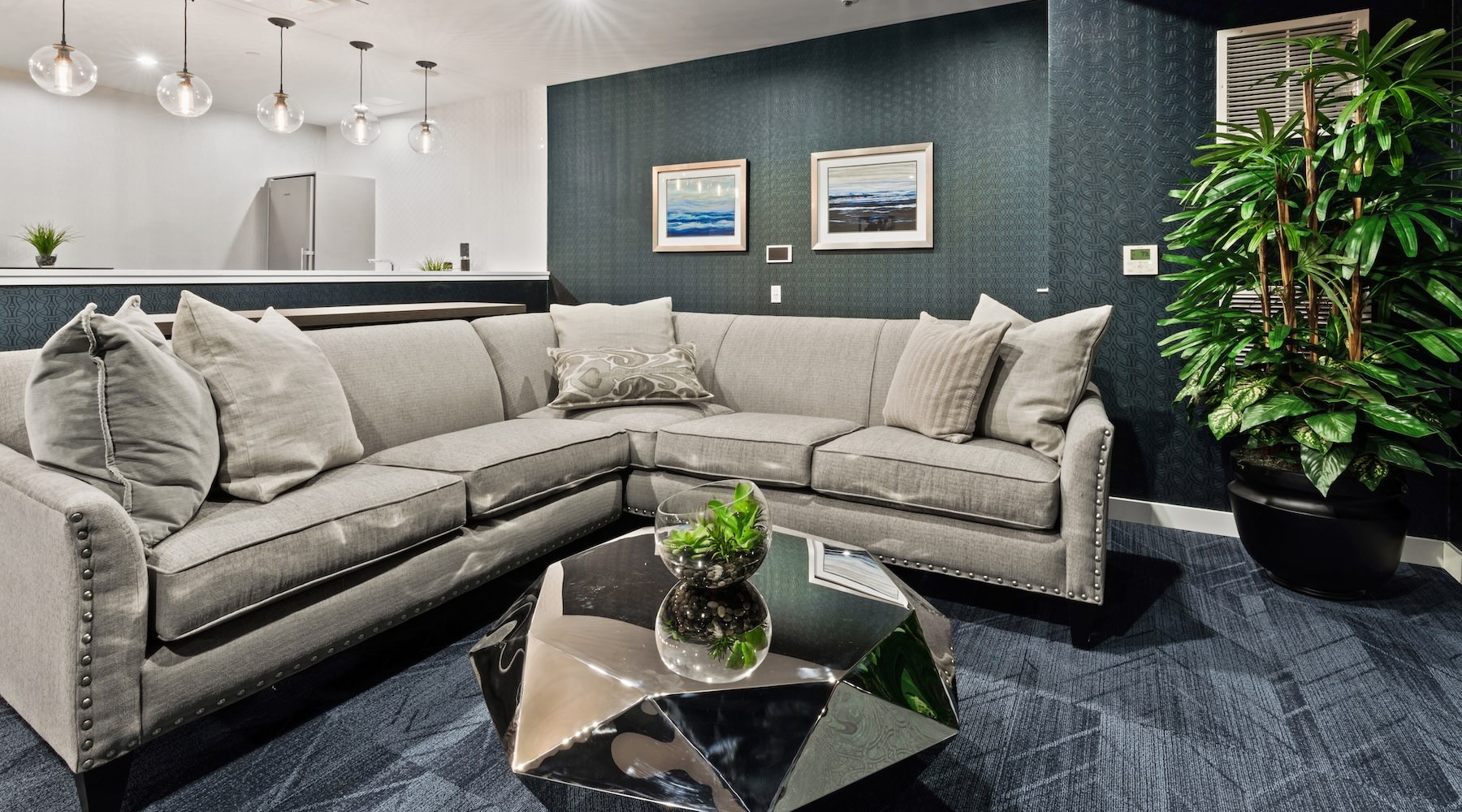 a clubhouse room with a large couch and a plant