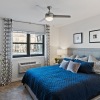 a bedroom with a blue bed and a plant