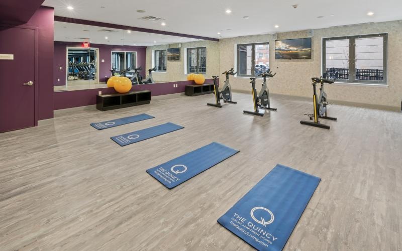 a room with exercise equipment and mats