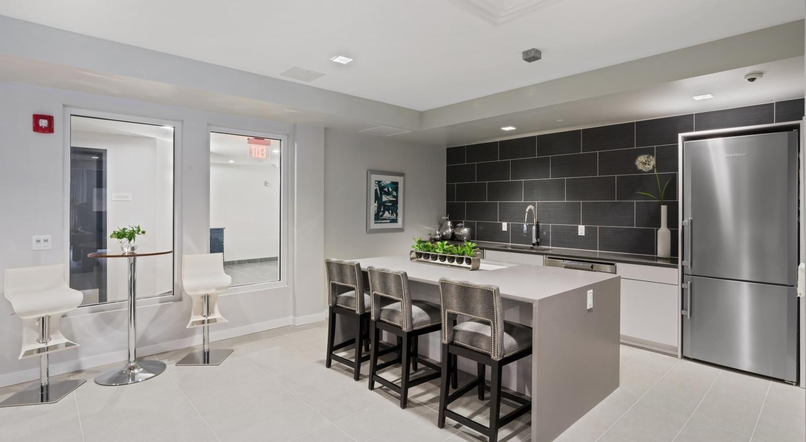 Everything within reach a community kitchen with a bar and chairs