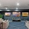 a room with a large wall of paintings and a couch
