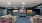 a room with a large wall of paintings and a couch