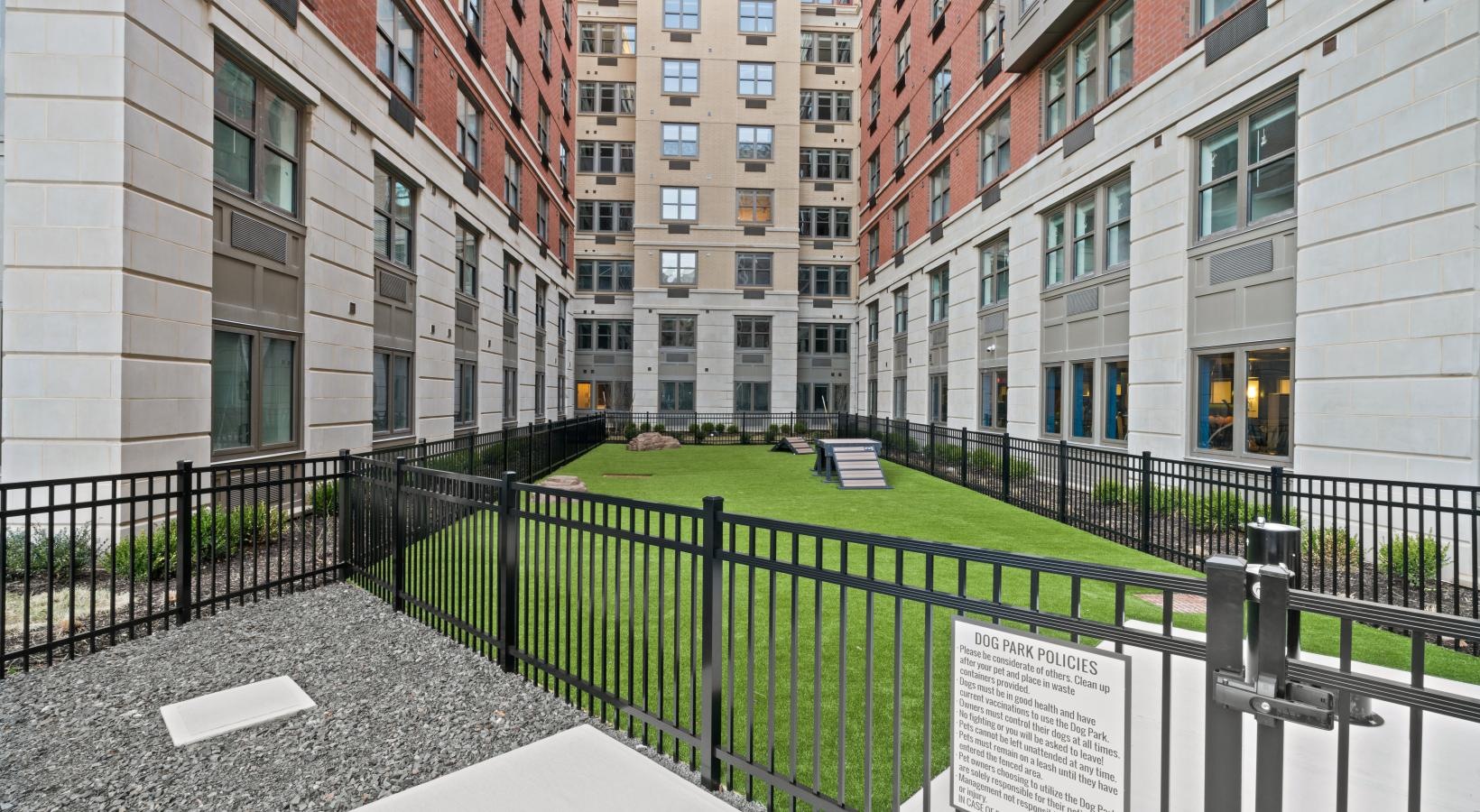 The essence of exceptional living a fenced in dog park with buildings around it
