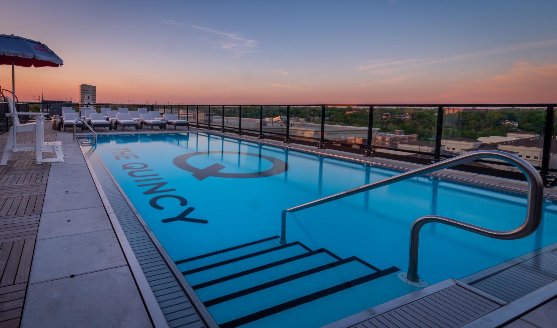 a pool with a deck and umbrella